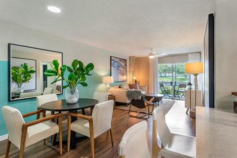 a living room and dining room with a table and chairs